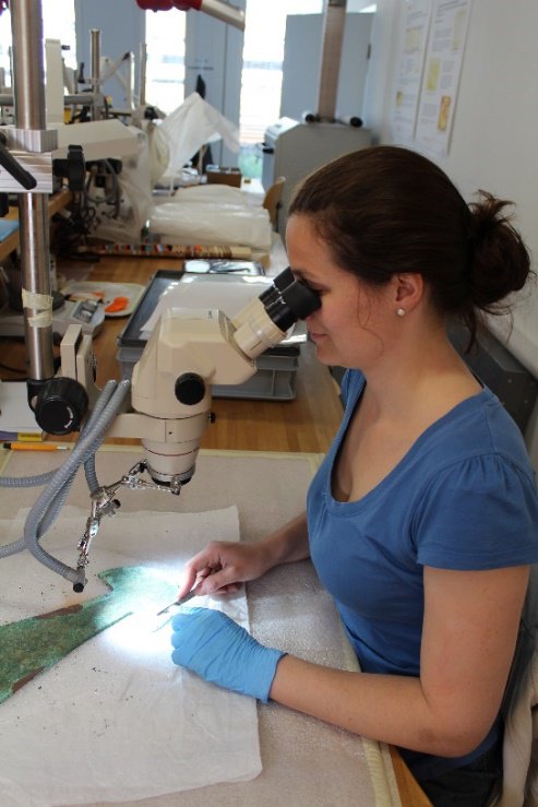 Visual observation of an artefact under a binocular microscope, (c) Jeanneret.